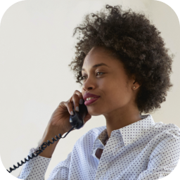 A side profile of a woman talking on a landline phone
