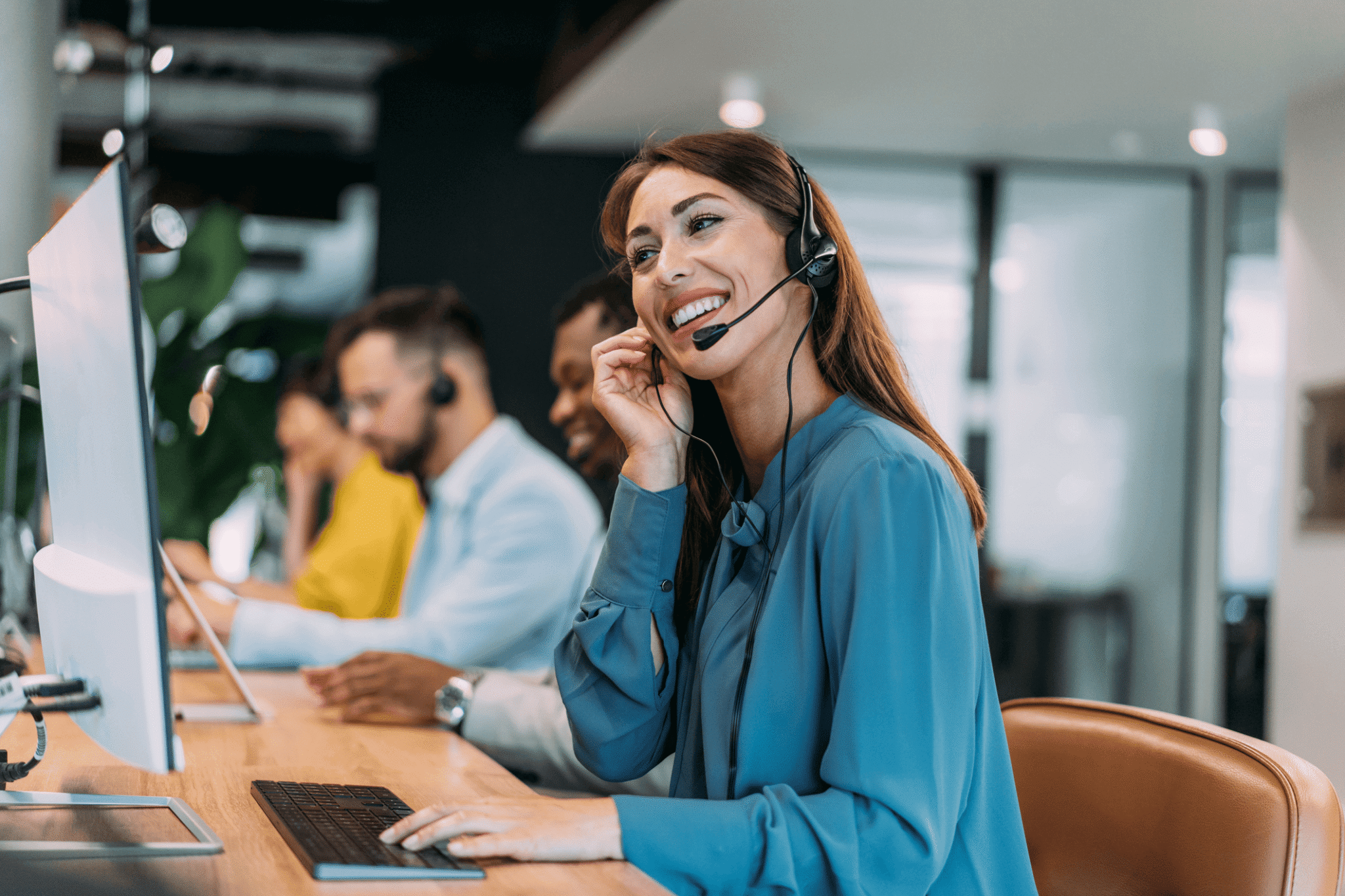 A smiling female contact agent in a row of agents