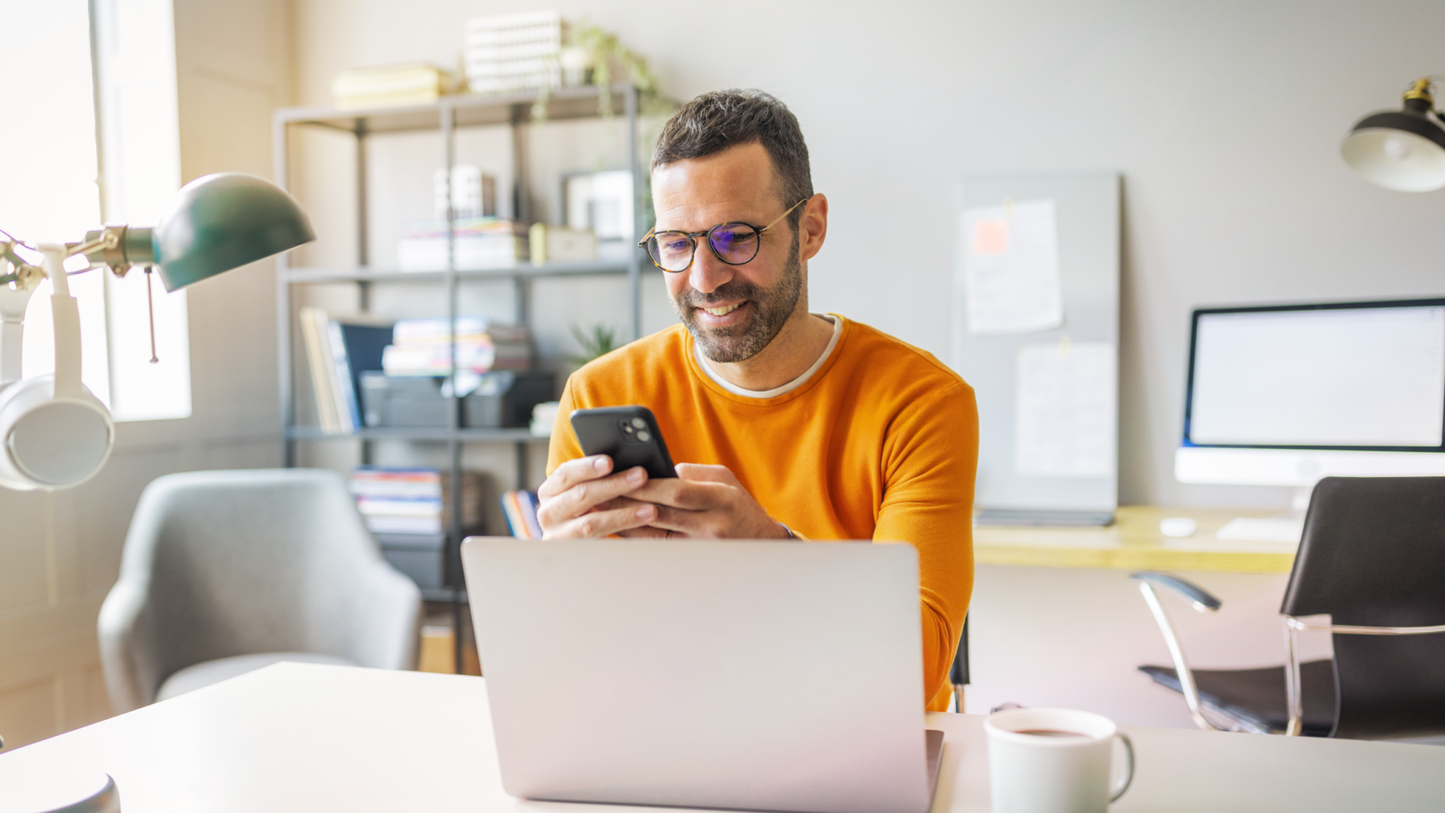 business owner configuring RingCentral AI Receptionist settings on laptop and mobile phone
